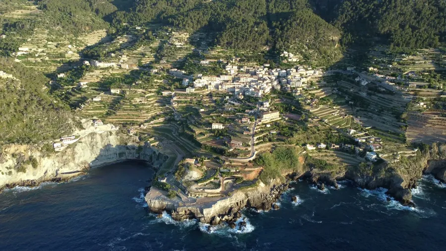 Banyalbufar aus der Luft mit seinen Terrassenfeldern über den Klippen der Westküste von Mallorca, am Abend